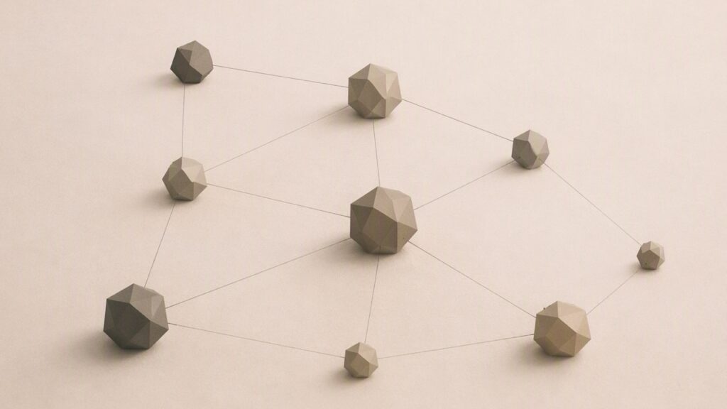 Ilustración conceptual en tonos papiro y grafito. Nueve formas geométricas facetadas de distintos tamaños aparecen conectadas entre sí mediante líneas finas, formando una red distribuida sin centro dominante. Las conexiones crean una estructura común en la que cada elemento mantiene su individualidad mientras participa en un conjunto compartido.